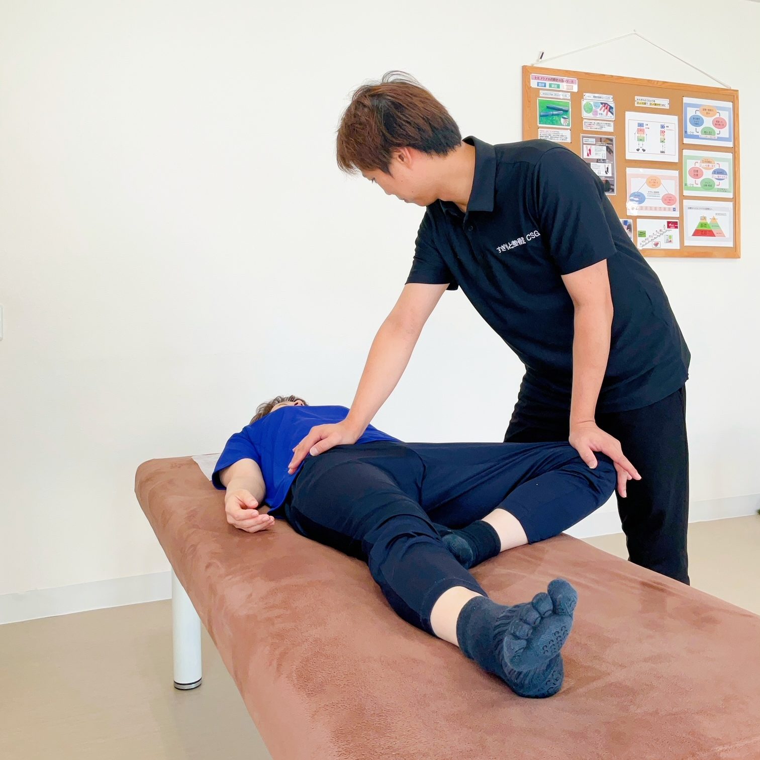柔道整復師による手技療法で、腰痛や姿勢の歪みなど不調の根本原因にアプローチ。股関節の可動域を診断し、骨盤や背骨を整える様子。